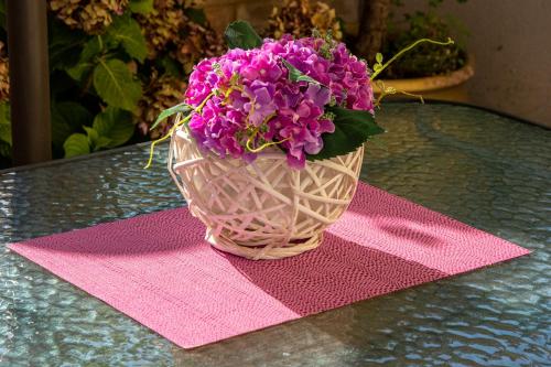 a vase filled with purple flowers sitting on a table at Irini Apartments in Kavala