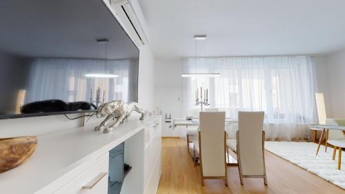 a white living room with a table and chairs at Apartment Puma v centre Piešťan in Piešťany