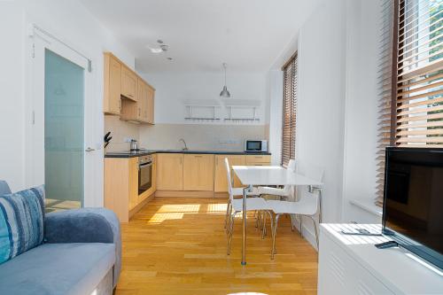 a living room with a couch and a table and a kitchen at Modern 1 Bed Flat in Holborn, London for up to 2 people with free wifi in London