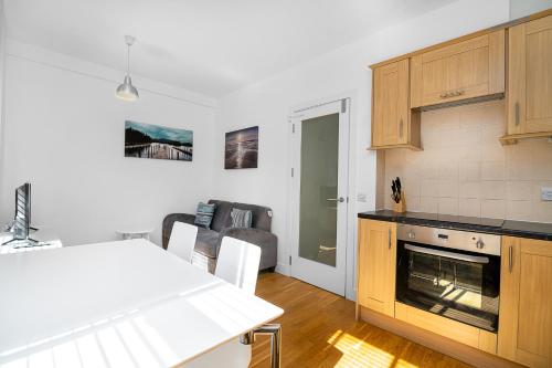 a kitchen with a table and a kitchen with a stove at Modern 1 Bed Flat in Holborn, London for up to 2 people with free wifi in London