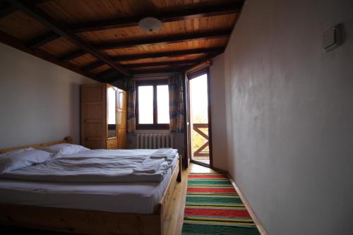 a bedroom with a bed and a large window at Belcheva kashta in Banya