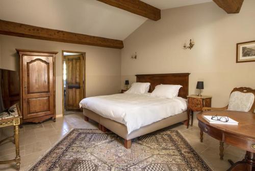 a bedroom with a bed and a table and a desk at Domaine De La Chapelle in Lorgues