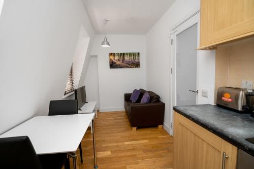 a kitchen with a counter top and a living room at Modern 1 Bed Flat for up to 2 people in Holborn, London with free wifi in London