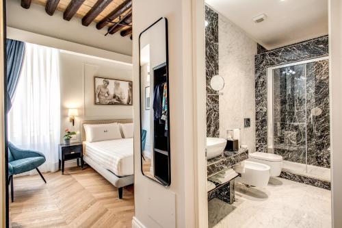 a bedroom with a bed and a bathroom with a sink at Babuino Palace&Suites in Rome