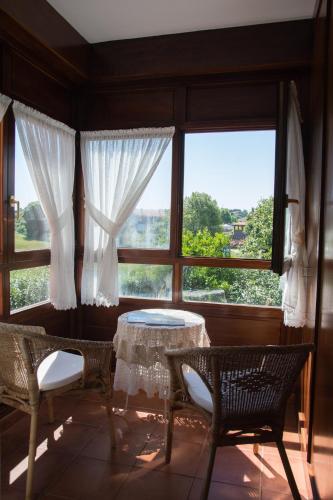 a room with a table and chairs in front of a window at Posada de Suesa in Suesa