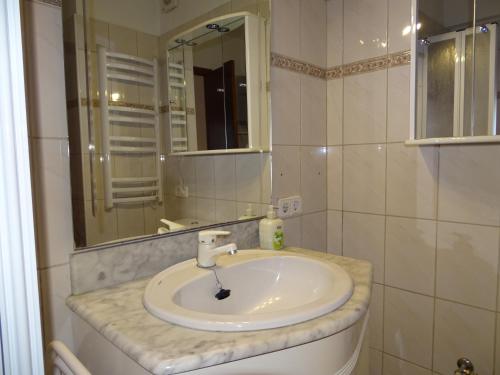 a bathroom with a white sink and a mirror at Mountain View Apartment in Port Alcudia in Port d'Alcudia