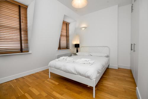 a white bedroom with a white bed and a window at Modern 1 Bed Flat in Holborn, London for up to 2 people - with free wifi in London