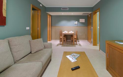 a living room with a couch and a table at Apartamentos Trisquel in Sanxenxo