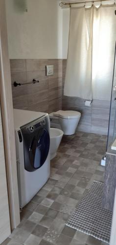 a bathroom with a toilet and a washing machine at Via Pezza 100 in Ragusa