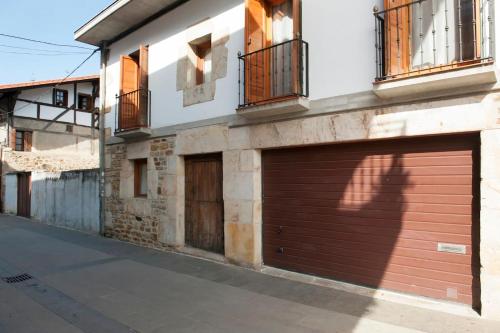 a building with two garage doors on a street at Casa Otxandi in Ochandiano