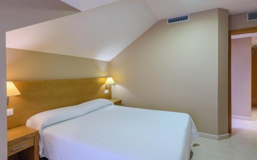 a bedroom with a large white bed in a room at Apartamentos Trisquel in Sanxenxo