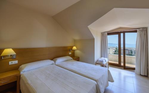 Кровать или кровати в номере Apartamentos Trisquel