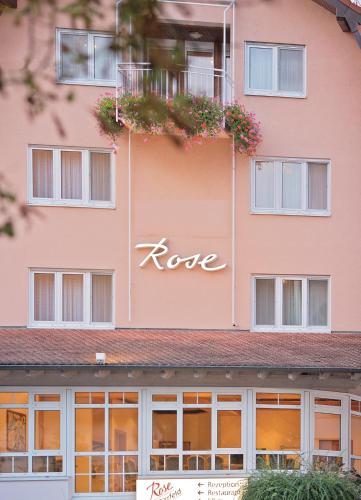 Un edificio rosa con la parola "rave" scritta sopra. di Pension Rose a Bretzfeld