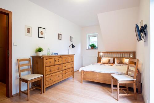 a bedroom with a bed and a dresser and a chair at Svycarska Bouda in Špindlerův Mlýn