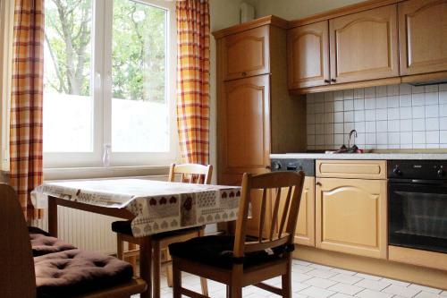 une cuisine avec une table et des chaises ainsi qu'une fenêtre dans l'établissement Ferienwohnung Kutschenmeyer, à Schneverdingen