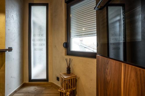a hallway with two windows and a wooden door at Bella Roe Premium Apartments in Belgrade