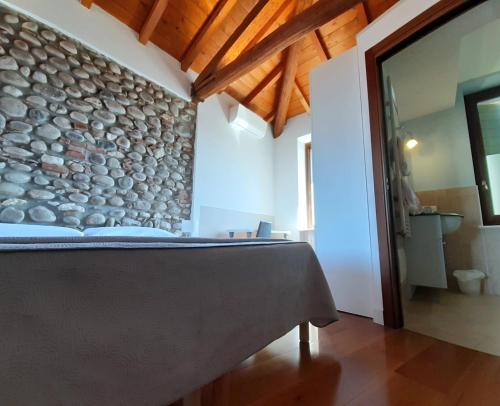 ヴェローナにあるDaniEli Camereの石壁のベッドルーム1室、ベッド1台が備わります。