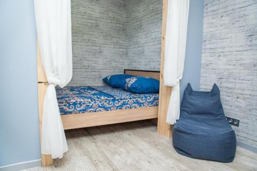 a bed with blue pillows in a room at Lux apartment on Nezalezhnoi Ukrаiny 39-B near Bulvar Shevchenko in Zaporozhye