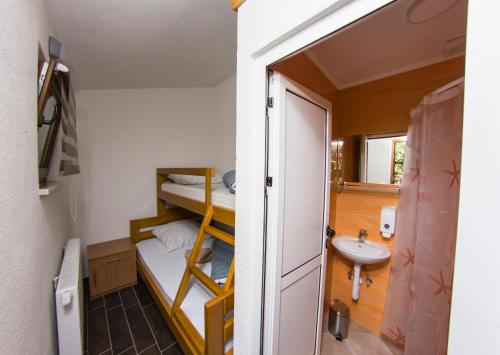 a small room with a bunk bed and a sink at Rooms Hercegovka in Čapljina