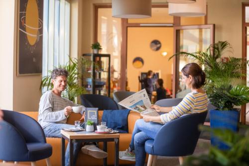 un grupo de personas sentadas en sillas en una habitación en JUFA Hotel Nördlingen, en Nördlingen