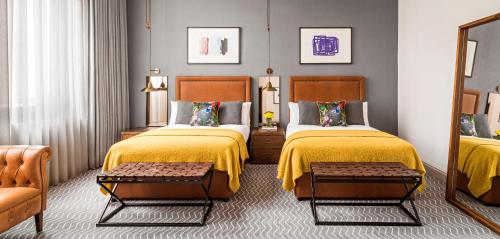 a hotel room with two beds and a couch at Kimpton Clocktower by IHG in Manchester