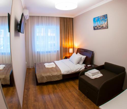 Pokój hotelowy z łóżkiem i krzesłem w obiekcie Embrace w mieście Truskawiec