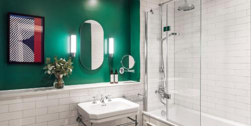 a bathroom with a sink, toilet and mirror at Kimpton Clocktower, an IHG Hotel in Manchester