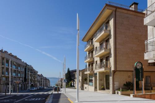 an empty street in a city with buildings at Apartamentos Trisquel in Sanxenxo