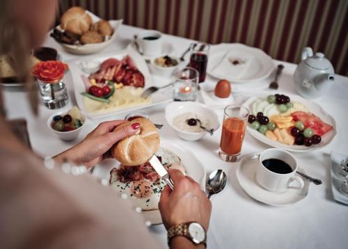 a person eating a sandwich at a table with food at Hotel Pichlmayrgut in Schladming