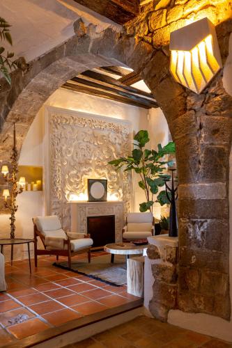 a living room with a fireplace and a stone wall at Hotel La Torre del Canonigo - Small Luxury Hotels in Ibiza Town