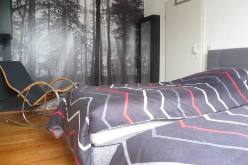 a bedroom with a bed with a black and white comforter at Ferienwohnung nördliches Münsterland in Greven