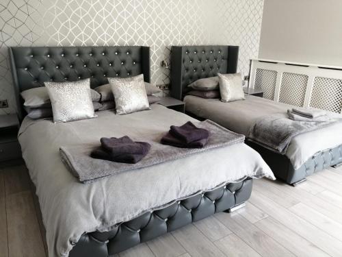 スカンソープにあるCosgrove Innの紫色の枕が付いたベッドルームのベッド2台
