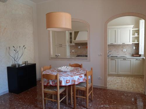 cocina con mesa con sillas y espejo en APPARTAMENTO CASA MARCO, en Capoliveri