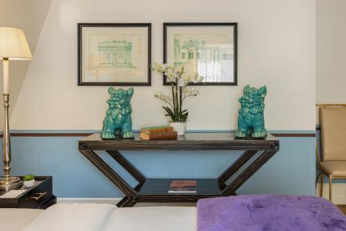 ein Wohnzimmer mit einem Tisch mit zwei blauen Katzen darauf in der Unterkunft House of Hütter - Heidelberg Suites & Spa in Heidelberg