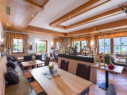 Alpengasthof Gruberhof في سول: مطعم بسقوف خشبية وطاولات وكراسي