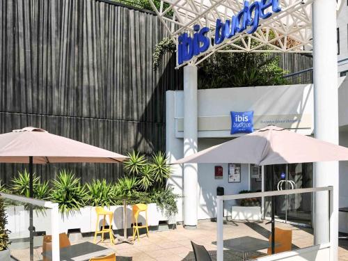 two umbrellas and chairs in front of a building at ibis budget Bordeaux Centre Mériadeck in Bordeaux