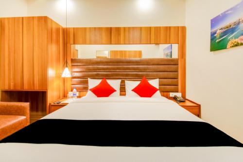 a hotel room with a bed with red pillows at INN THE CENTRE in Nellore
