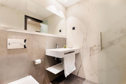 a white bathroom with a sink and a shower at Ronda House in Barcelona