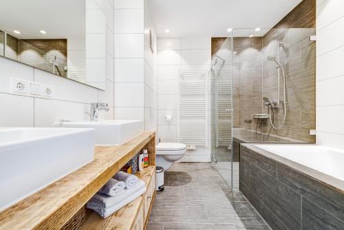 a white bathroom with a sink and a toilet at Appartement Valbona Blick by A-Appartments in Bürserberg