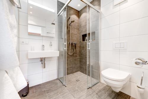 a bathroom with a shower and a toilet and a sink at Appartement Valbona Blick by A-Appartments in Bürserberg