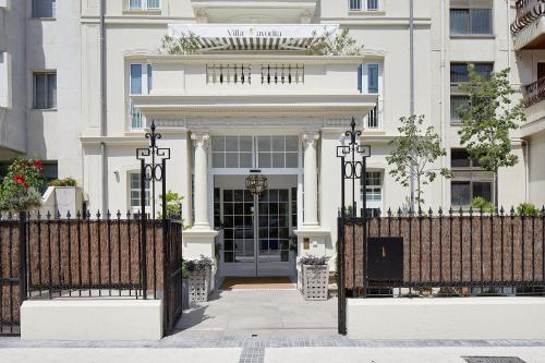 a white house with a gate and a building at Hotel Boutique Villa Favorita in Donostia-San Sebastián