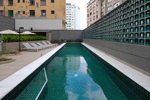 einem Pool an der Seite eines Gebäudes in der Unterkunft 360 Suítes Sé in São Paulo