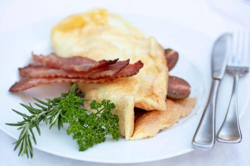 een bord met ontbijtproducten met spek en toast bij Brooklyn Manor in Pretoria