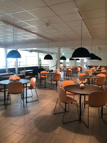 un comedor con mesas, sillas y luces en Ansgar Summerhotel en Kristiansand