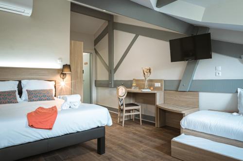 a hotel room with two beds and a desk at Hôtel du Pont in Ascain