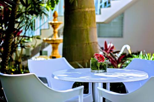a white table and chairs with a vase of flowers on it at Villa Venezia in Fort Lauderdale