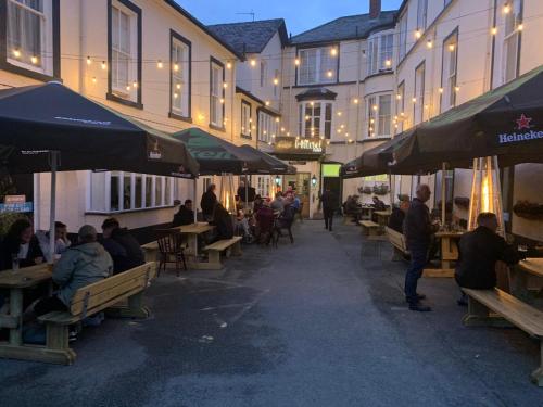 un grupo de personas sentadas en mesas fuera de un edificio en The Hand Hotel, en Llangollen