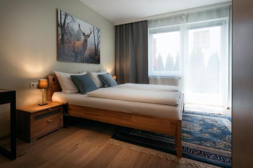 um quarto com uma cama grande e uma janela em Ski-In/Ski-Out Appartements Augasse by Schladming-Appartements em Schladming