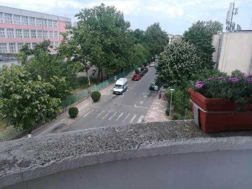 a view of a street from a balcony with a flower pot at Къща за гости ЕЛИ in Primorsko
