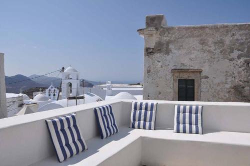 two blue and white pillows sitting on a balcony at Chora Elegant Traditional House in Amorgos
